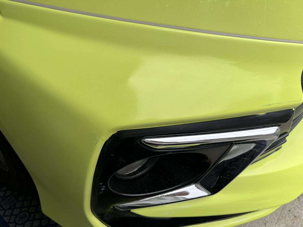 傷が目立たなくなった車のバンパー。作業後に塗装面がなめらかになっており、傷はほぼ見えない。